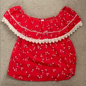 Red off the shoulder shirt with white flowers.